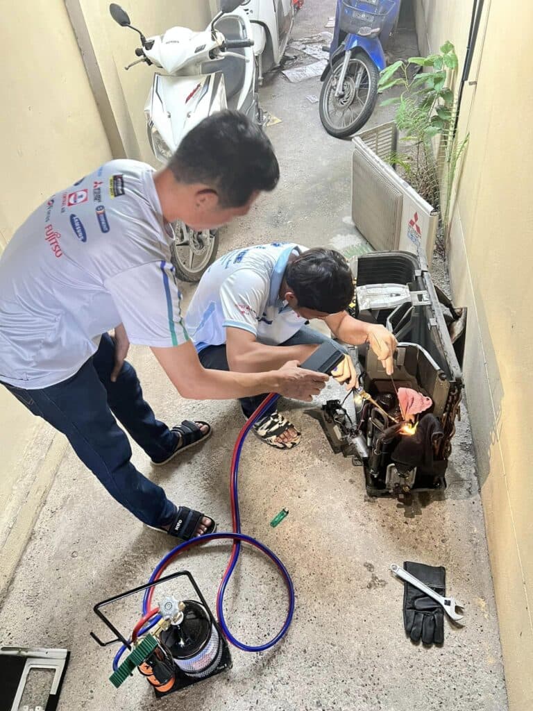 ช่างแอร์เชียงใหม่กำลังล้างแอร์ถึงบ้านลูกค้า พร้อมปูผ้าใบคลุมพื้นที่โดยรอบ